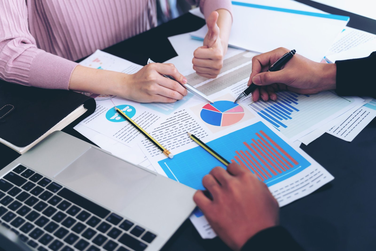 close up hand business man busy office desk notebook documents working